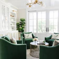 Small conversation cluster featuring four green swivel chairs around a round table in a bright, modern living space.