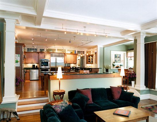Traditional split-level open-concept design featuring a raised kitchen, decorative columns, and a cozy living area on the lower level.