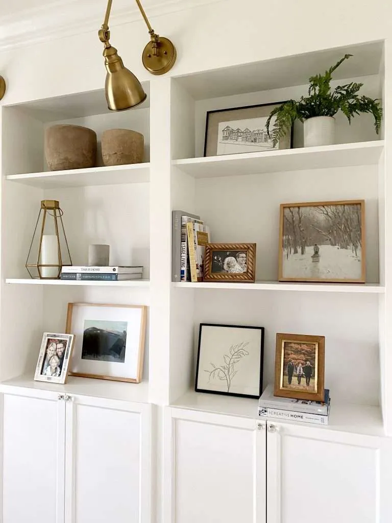 Minimal built-in shelves styled with framed photos, books, and neutral decor to reduce visual clutter during a winter home reset.